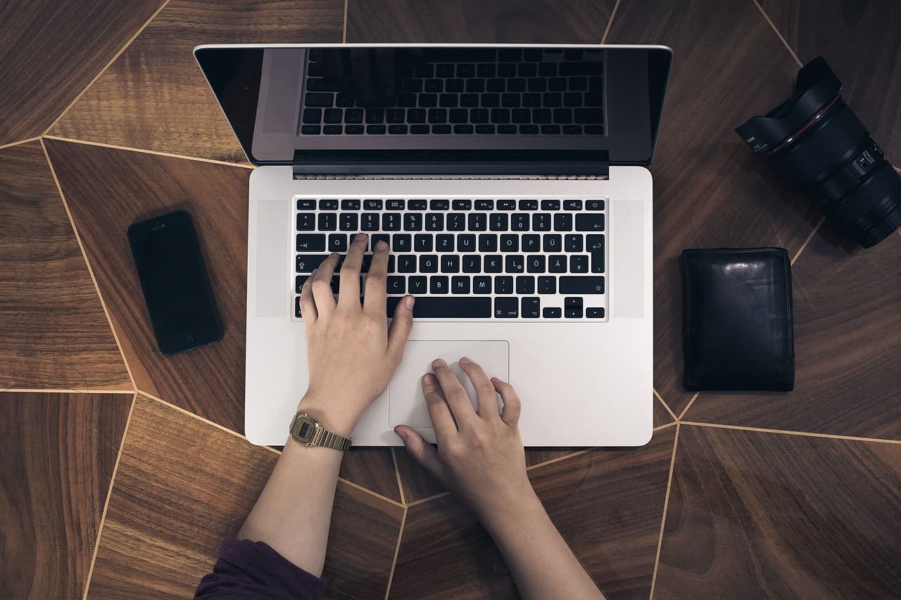 Hands typing on a laptop